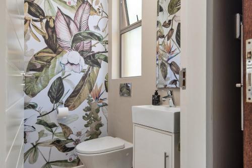 巴利托56 Zimbali Wedge的一间带卫生间的浴室和花卉壁纸