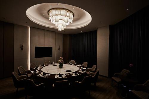台州万斯国际酒店(临海杜桥店)的大型客房配有桌椅和吊灯。