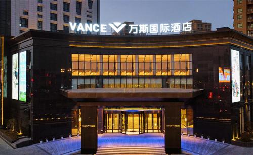 台州万斯国际酒店(临海杜桥店)的一座大建筑,上面有标志