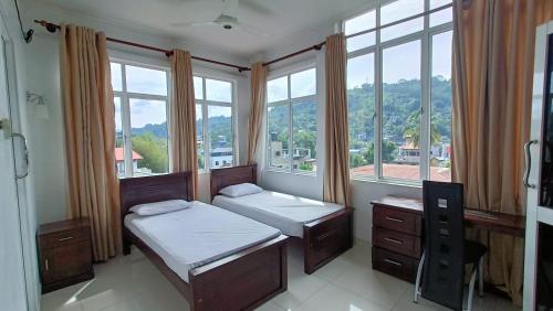 康提Smile Hub Kandy Penthouse apartment的一间卧室设有两张床和美景窗户。