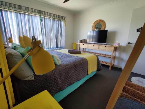 玛格丽特河Stylish Colourfull Getaway的一间卧室设有一张床、一台电视和一个窗口。