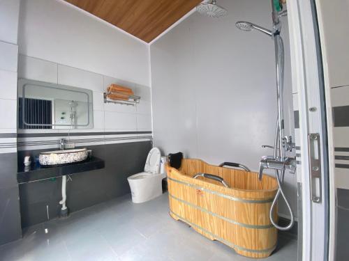 Bảo LạcBảo Lạc - Sunny Homestay的浴室设有位于卫生间旁的木制浴缸。