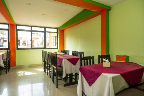 加德满都Kathmandu Peace Hotel的用餐室设有多彩的墙壁,配有桌椅