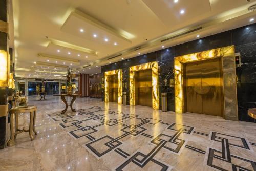 吉达Paradise Inn Jeddah Hotel的大堂设有金色和黑色的墙壁,铺有大理石地板
