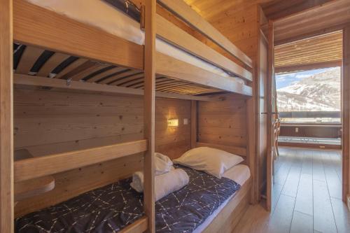 瓦勒迪泽尔Résidence Les Cîmes - Centre Val d'Isère的木制客房设有两张双层床和窗户。