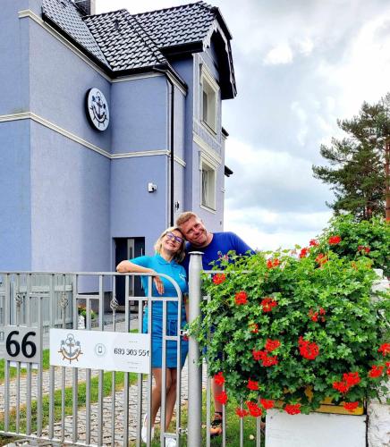 尤斯托尼莫斯基Villa Blue Mare的站在房子前面的围栏上的男女
