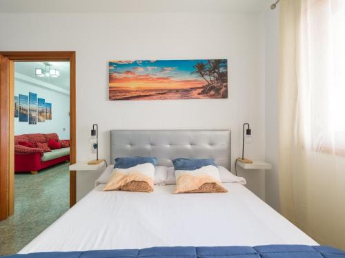 大加那利岛拉斯帕尔马斯Bluebeach的卧室配有一张带两个枕头的大白色床