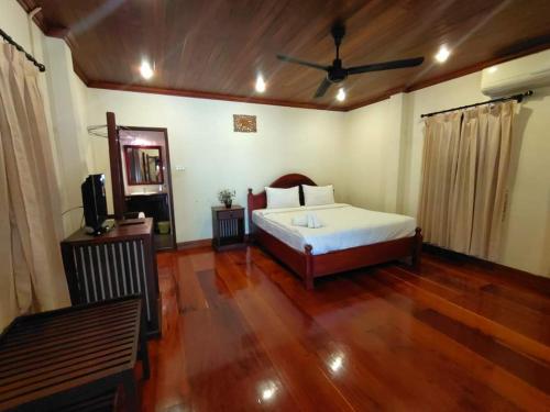 琅勃拉邦somvang khily guesthouse 宋旺吉利 酒店的一间卧室配有一张床和吊扇
