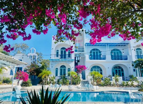 金兰Santorini Villa Cam Ranh的一座别墅,设有游泳池和粉红色的鲜花