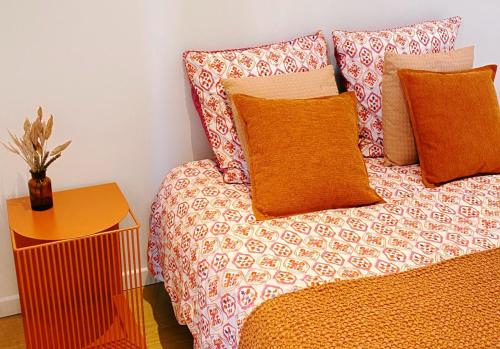 DéolsLe Bohème ⸱ Stationnement gratuit ⸱ Fibre的一张带橙色枕头的床和一张带植物的桌子