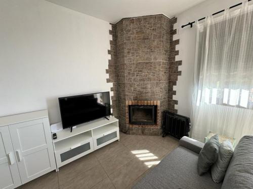 贝瑙卡斯apartamento arroyo的一间带电视和壁炉的客厅