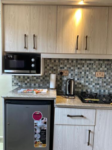 埃尔多雷特Regency Homes II的厨房配有黑色冰箱和微波炉。