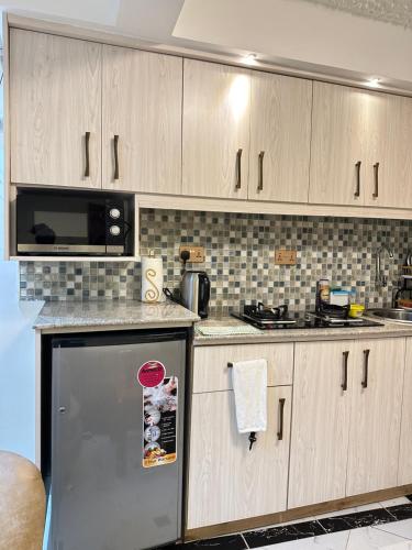 埃尔多雷特Regency Homes II的厨房配有木制橱柜和不锈钢冰箱。
