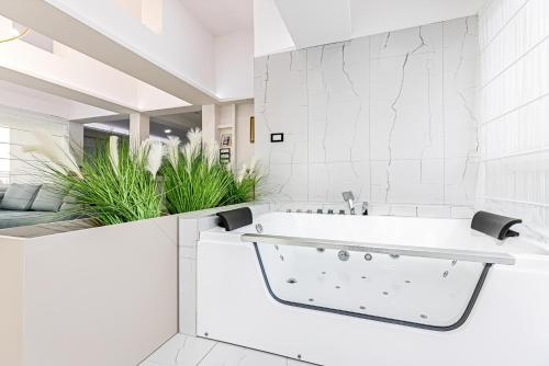 贝尔格莱德ForS Resort & Spa的白色的浴室设有浴缸和植物