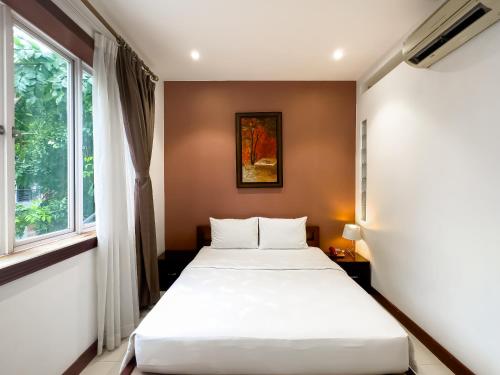 胡志明市Hoang Yen Hotel - Phu My Hung的一间卧室设有一张床和一个窗口