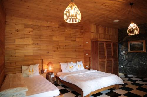 河江Ha Giang Historic House & tour的木墙客房的两张床