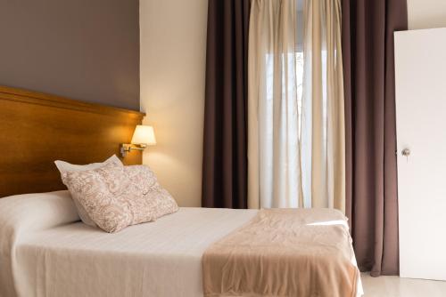 梅里达Imperial Mérida的一间卧室配有一张带枕头和窗户的床
