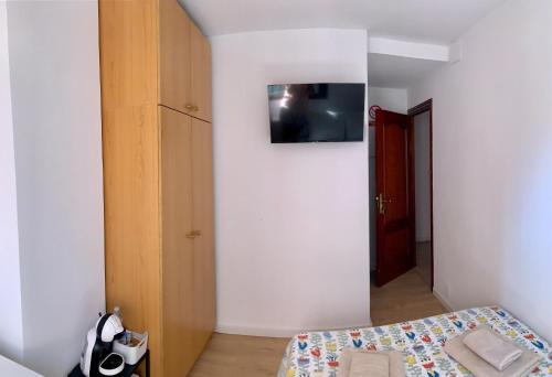 马拉加Habitación González的一间卧室配有一张床,墙上配有电视