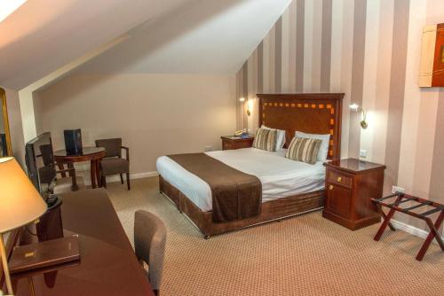 索布里奇沃思格鲁夫庄园高尔夫酒店&乡村俱乐部的卧室配有一张床和一张桌子及椅子