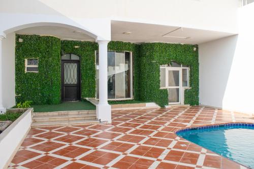 杜拉特阿拉尔فلل منتجع درة العروس بي شاطئ رملي علي البحر的一座带绿色墙壁和游泳池的房子