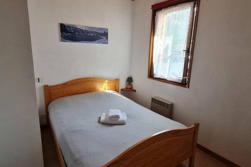 拉布雷斯Gîte Le Bressaud的一间卧室配有一张带白色毛巾的床