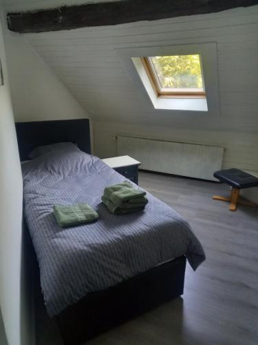 蒙绍joseph的一间卧室配有一张带两张绿毛巾的床