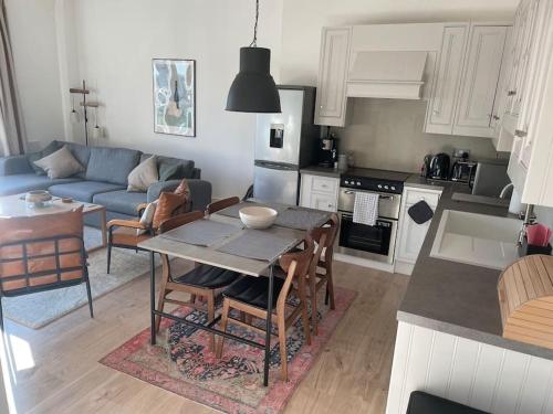 利物浦Stylish city-centre apartment with balcony的厨房以及带桌子和沙发的客厅。