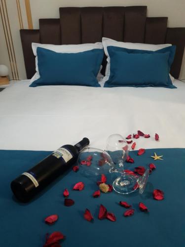 RebrovacApartman ADA Banja Luka的床上一瓶葡萄酒和玫瑰