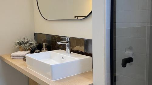 梅珀尔bij DE RODE DEUR的浴室设有白色水槽和镜子