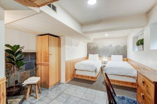 班夫Banff Three Bedroom Basement Suite的一间卧室配有两张床和一张桌子及椅子