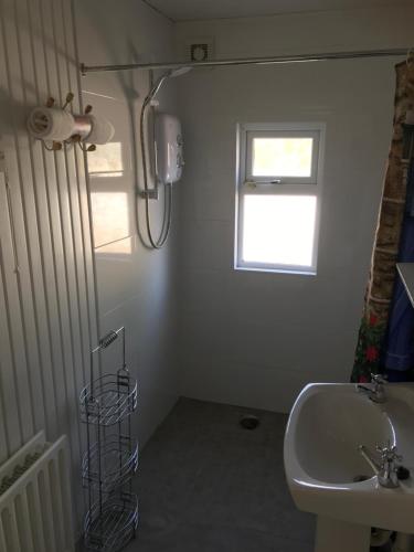 KillashandraBrigid M’s Farm House的白色的浴室设有水槽和窗户。