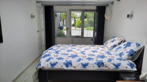 巴勒哈姆斯泰德B&B ZEEUWS KNOOPJE的一间卧室,床上摆放着蓝色鲜花