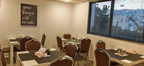 瓦迪穆萨埃及艳后酒店的一间带桌椅的用餐室和窗户。