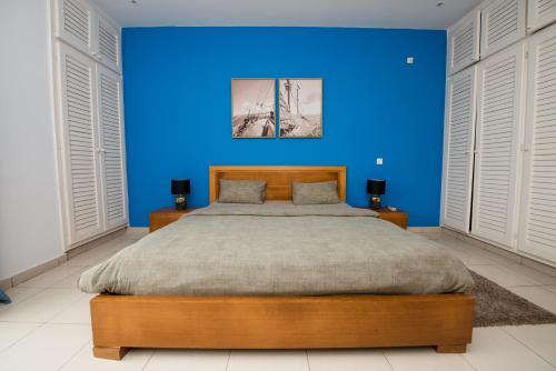 黑角Duplex moderne avec vue exceptionnelle sur la mer的蓝色卧室设有一张带蓝色墙壁的大床
