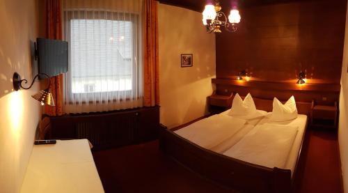 克查赫Gasthof-Fleischerei Engl的一间卧室配有一张带白色床单的床和一扇窗户。