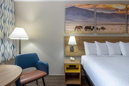 罗斯威尔罗斯韦尔戴斯酒店的酒店客房配有一张床、一张桌子和一把椅子。