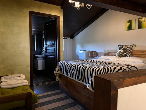 圣埃乌费米亚阿马伊埃拉CASA MUPI的一间卧室配有斑马打印床和一间浴室