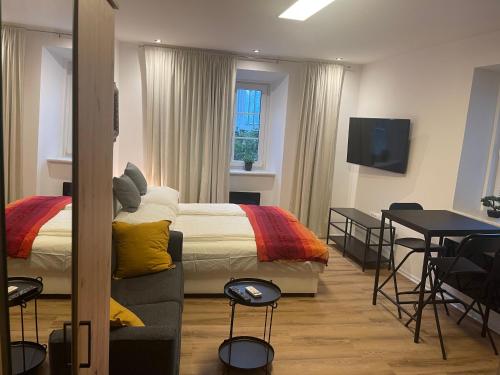 采列Celje Luxury Apartments & Spa的一间卧室配有一张床、一张桌子和一台电视