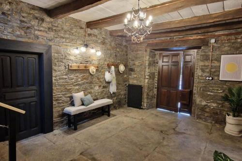 Caboalles de AbajoLa Escondida的一间设有石墙、长凳和吊灯的房间