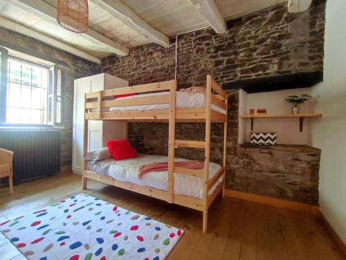 Caboalles de AbajoLa Escondida的卧室设有2张双层床,位于砖墙内