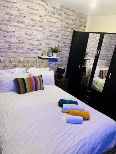 巴尔金One Bedroom Apartment Barking的卧室配有带枕头和镜子的白色床