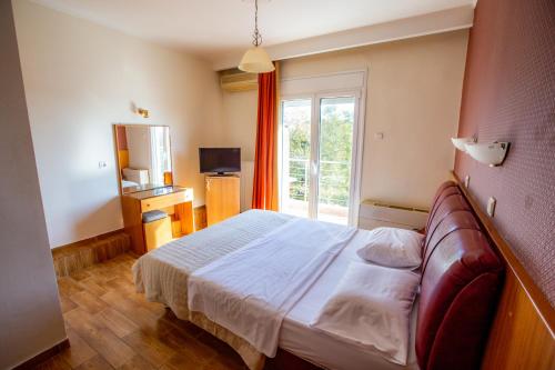 KimmériaGiannis Hotel的酒店客房设有床和窗户。