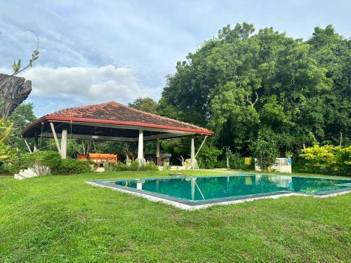 NikaweratiyaMagalle Wewa Villa的一个带凉亭的庭院内的游泳池