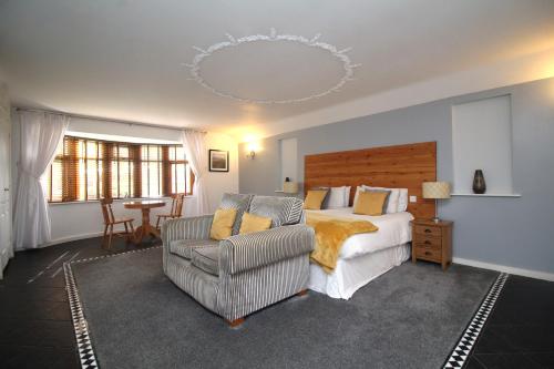 彼得伯勒Highfields Holidays bed & breakfast的一间卧室配有一张床、一张沙发和一把椅子