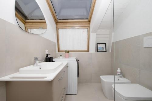 米兰Double Luxury Exclusive Suite-Duomo in 12 Minutes的一间带水槽和卫生间的浴室以及窗户。