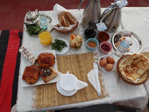 布马伦Hôtel Riad Atlas Dades的餐桌上摆放着早餐食品和橙汁