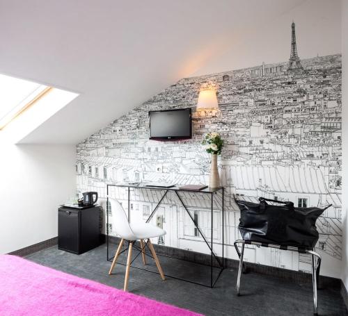 巴黎维多利亚沙特莱酒店的客房设有砖墙、书桌和电视。