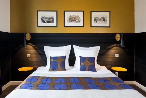 巴黎维多利亚沙特莱酒店的一间卧室配有一张大床和两个枕头