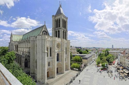 圣但尼Le Duplex Paris Basilique Stade de France的一座城市中一座带钟楼的大型大教堂