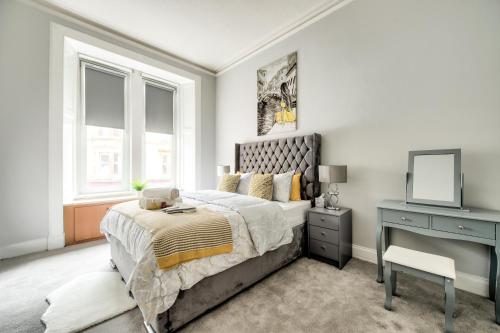 格拉斯哥Two Bed Stylish Apartment in Heart of West End的一间卧室配有一张床和一张带镜子的书桌